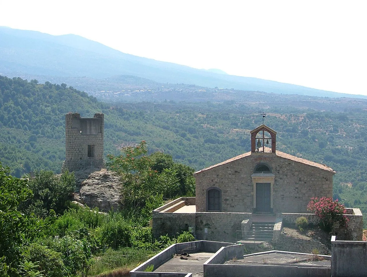 A church and tower in Castiglione di Sicilia, with Etna behind